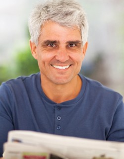 Man smiling with newspaper