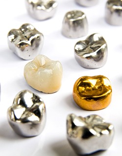 Dental crowns made of a variety of materials lying on a table