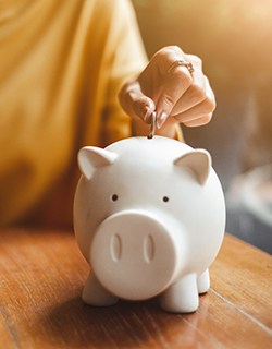 Coin being put into a piggy bank