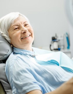 older woman admiring her smile in a mirror