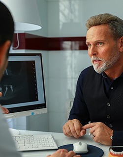 A male patient listening as his dentist explains whether he will need preliminary treatment before receiving dental implants in Mount Pleasant