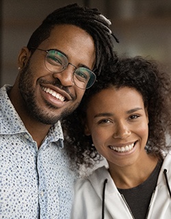 A man and woman smile together after having a few teeth replaced with dental implants in Mount Pleasant