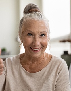 smiling woman who dental implants can help