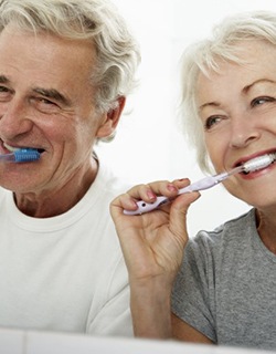 elderly couple brushing their teeth