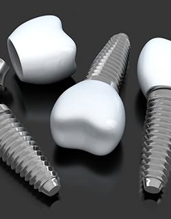 three dental implant posts with abutments and crowns