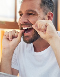 Closeup of man smiling while flossing