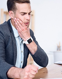 Man rubbing jaw prior to TMJ therapy in Mt. Pleasant, TX