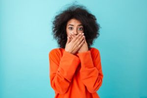 a woman clasping her hand over her mouth in shock when her filling fell out