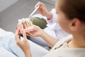 dentist explaining the basics of dental implants to a patient 