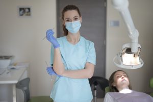 Hygienist at dentist wearing a face mask.