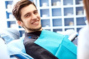 man in dentist chair smiling 